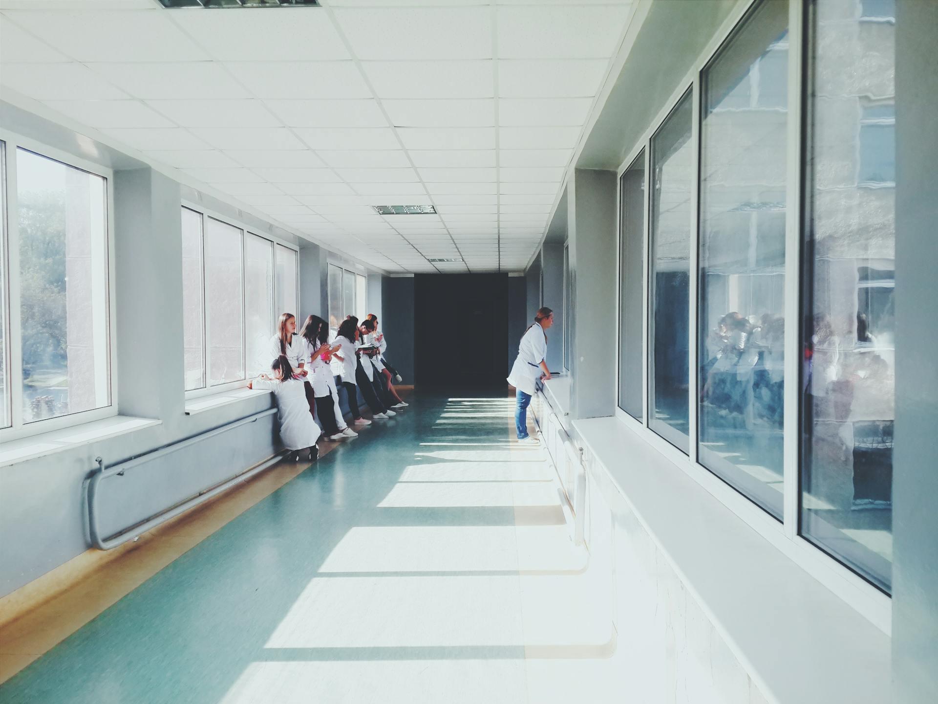 doctors looking through a widow in a hospital hallway